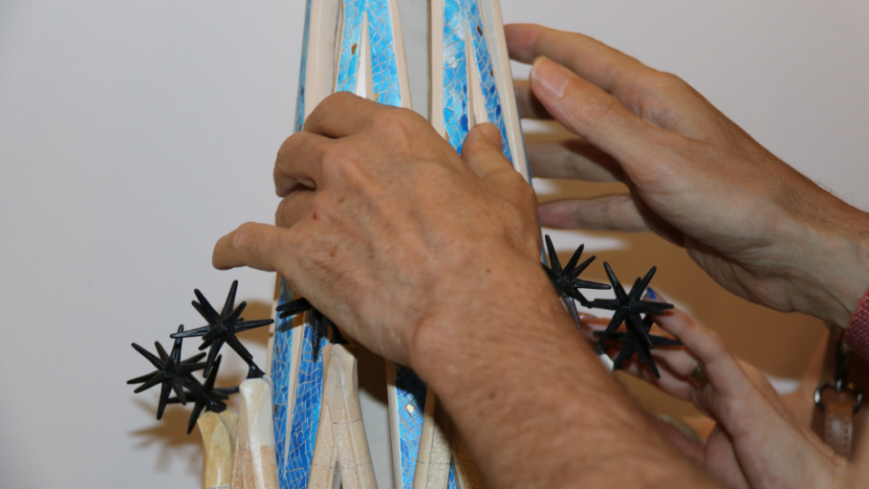 Una persona invident tocant els detalls de la nova maqueta tàctil de la Torre de Maria de la Sagrada Família | Eli Don, ACN